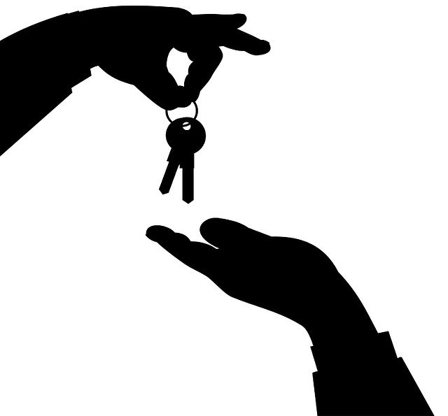 ruka podává klíč od bytu